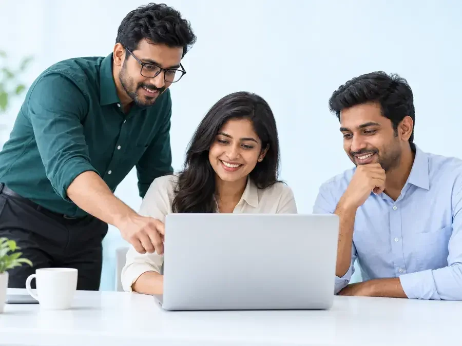 Three colleagues collaborating at a laptop